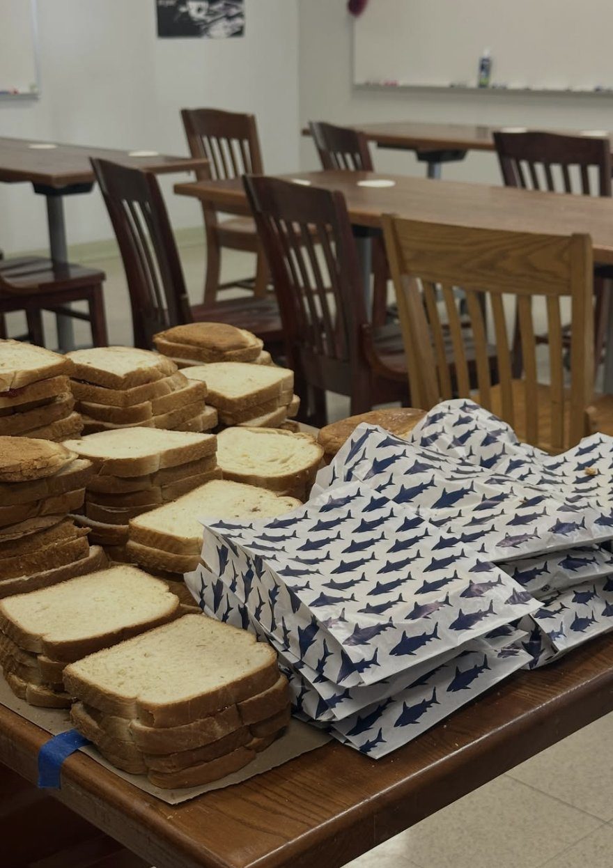 Stacks of finished sandwiches and paper bags